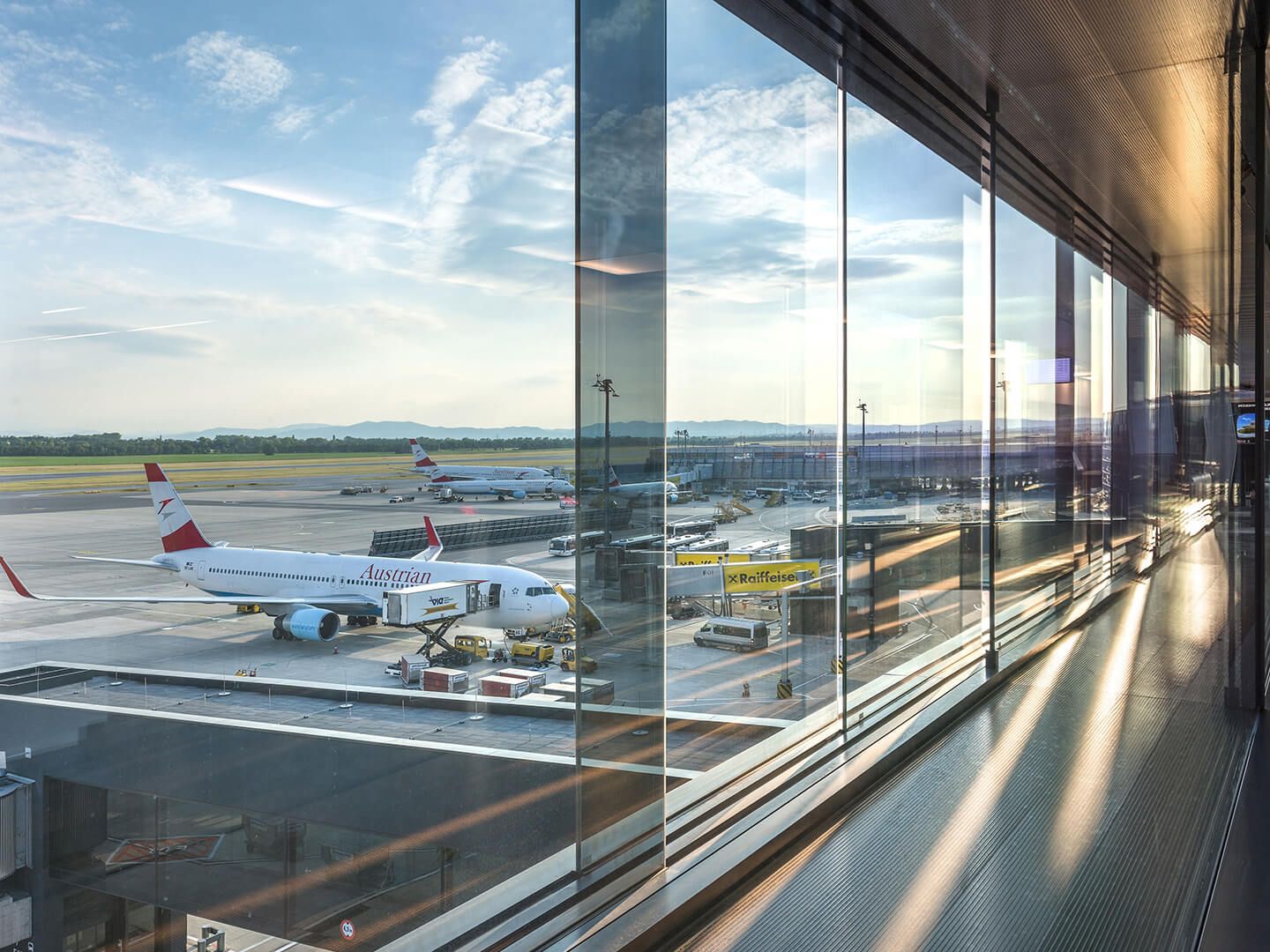 Flugzeuge der Austrian Airlines am Gate eines Flughafens bei Sonnenlicht