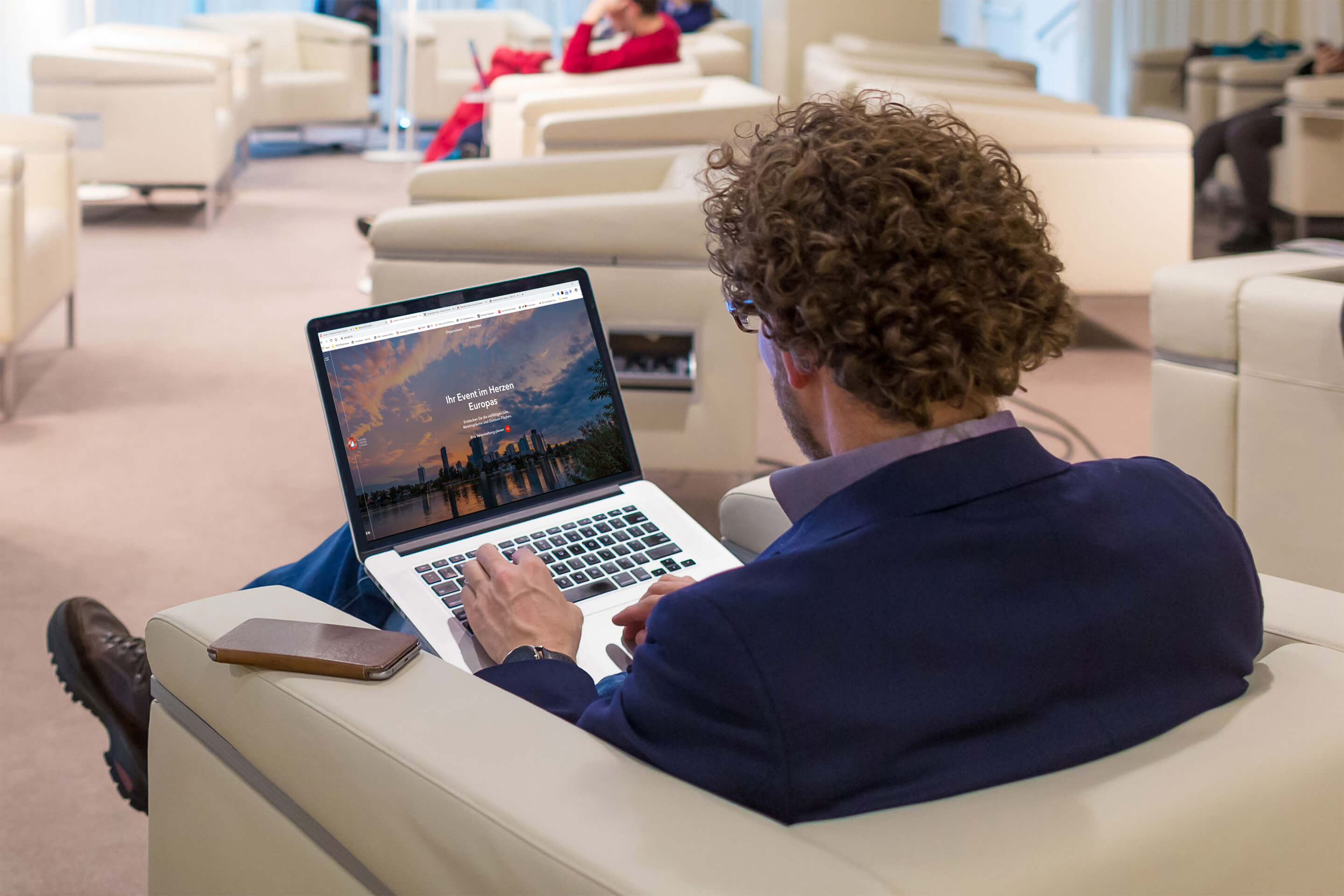 Foto: Mann sitzt in der Business Lounge des Austria Center Vienna und surft im Internet.