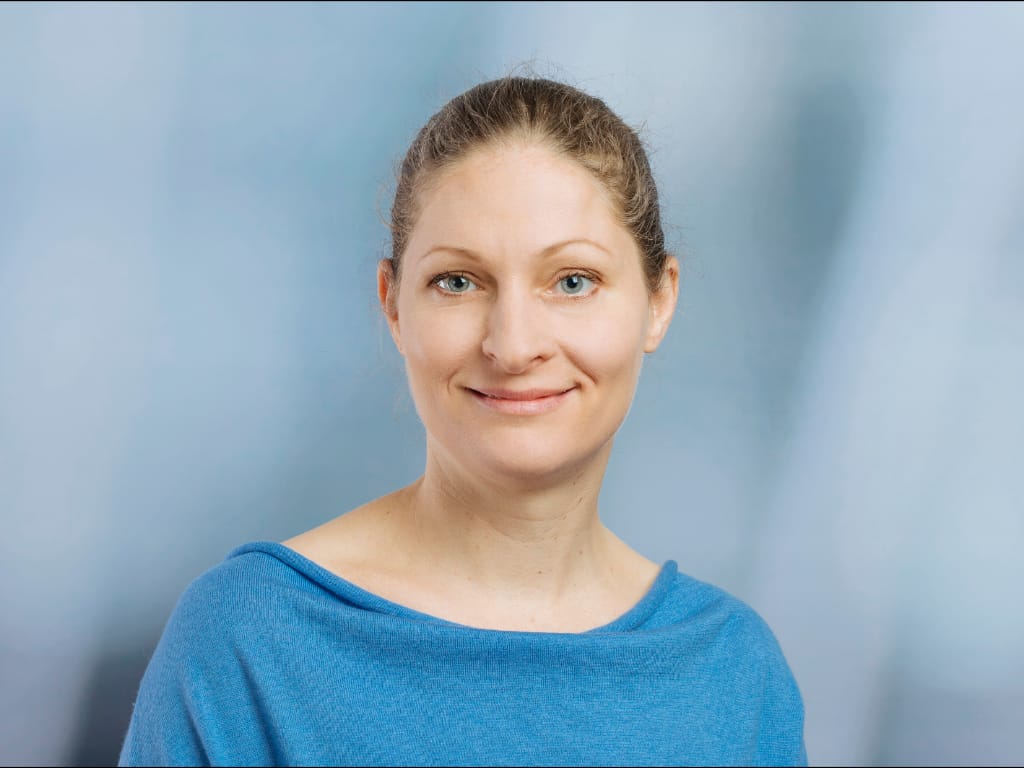 Person wearing a blue top against a light blue background