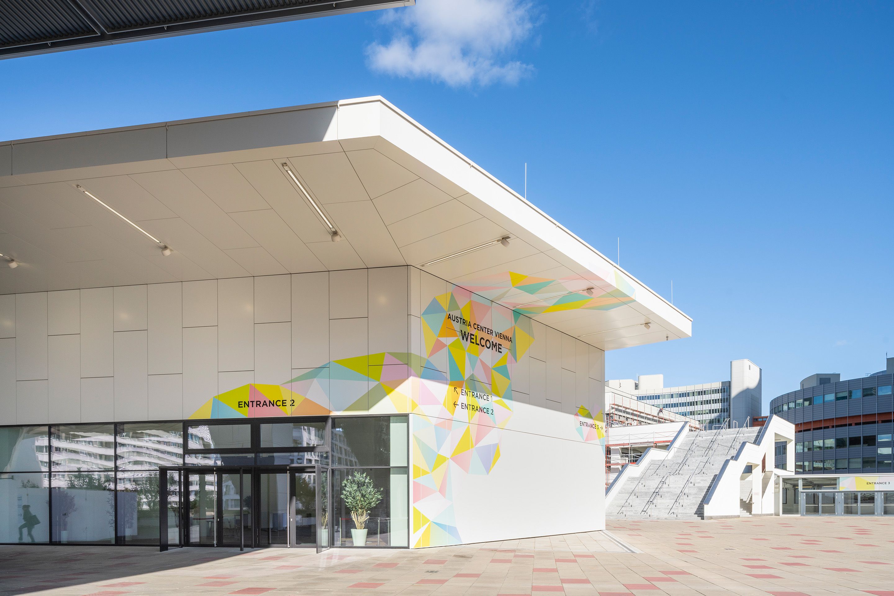 Austria Center Vienna entrance with colorful geometric wall art and directional signs
