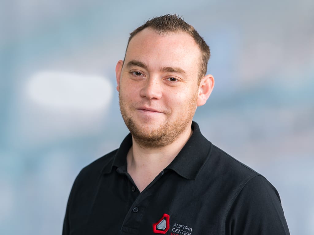 Person wearing a black polo shirt with Austria Center logo on the chest