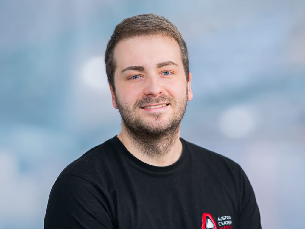 Person wearing a black t-shirt with a red and white Austria Center Vienna logo on the chest