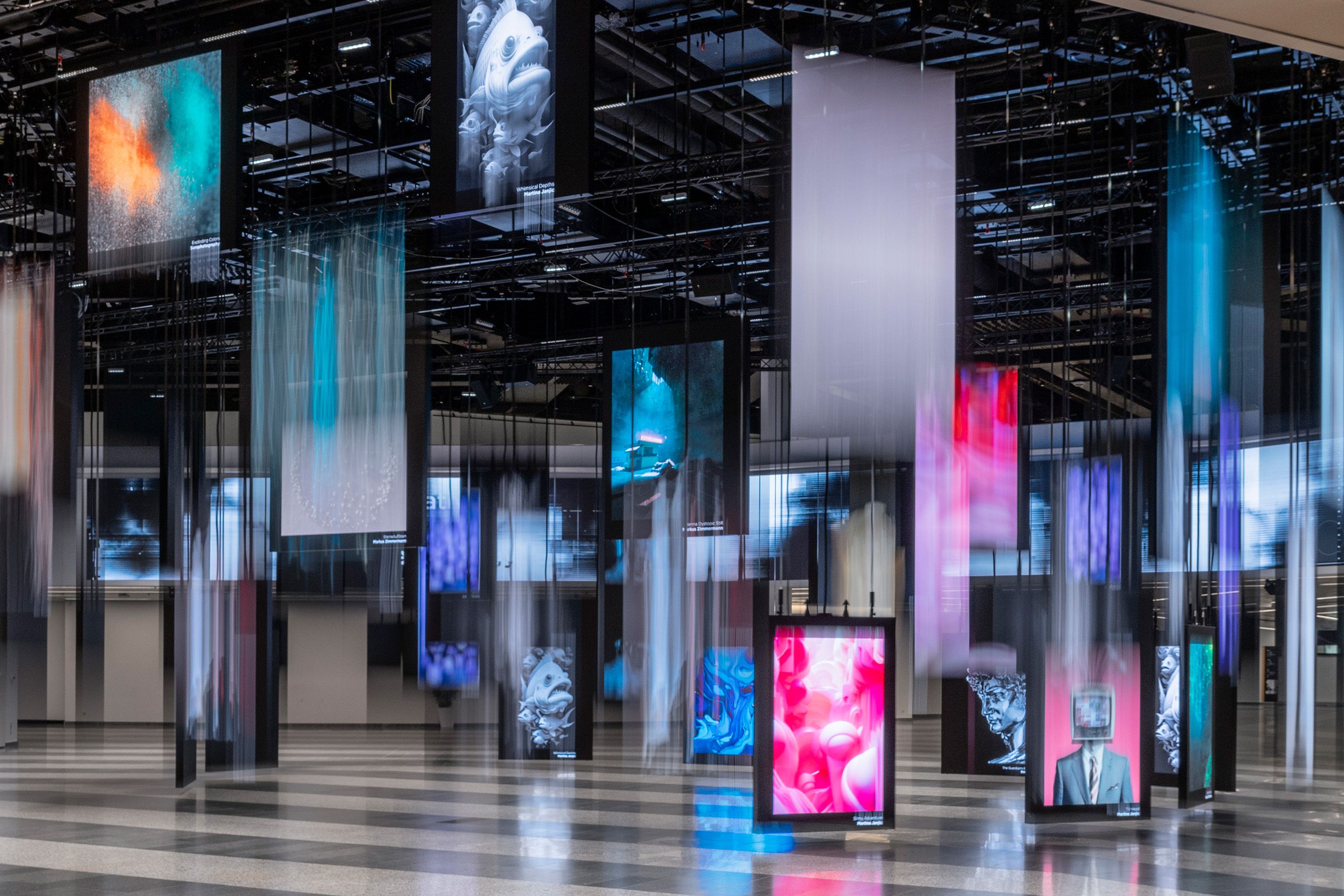 Digital art panels hanging from ceiling in a large indoor space with blurred motion effects