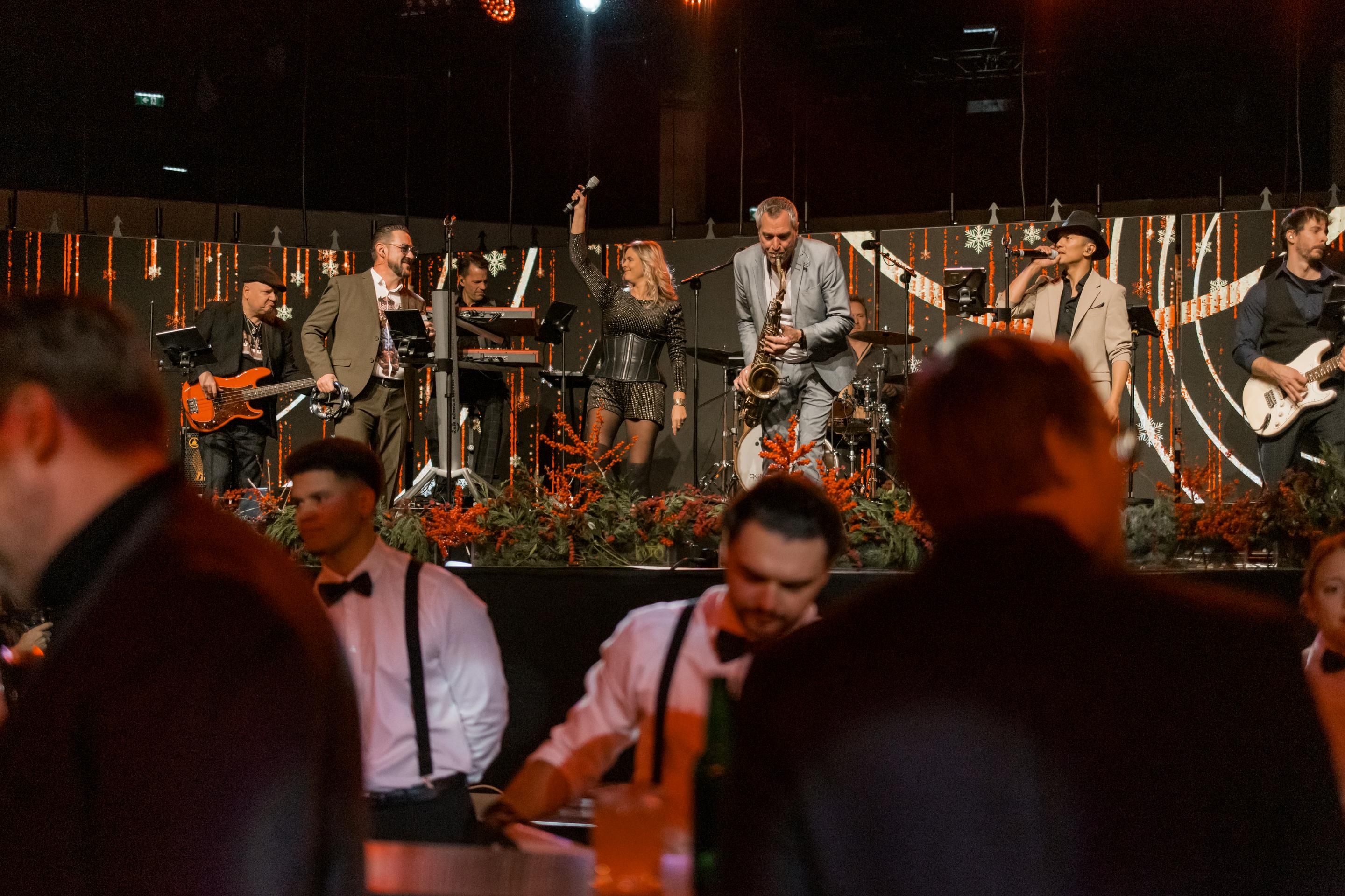 Band mit Sängerin, Saxofonist und weiteren Musikern auf Bühne mit Weihnachtsdeko