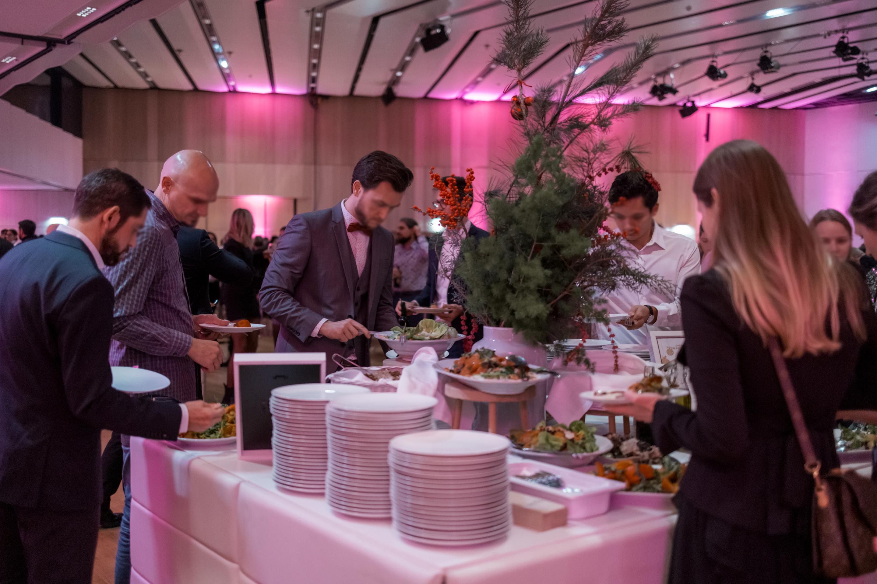 Foto: Menschen an einem weihnachtlich dekorierten Buffet