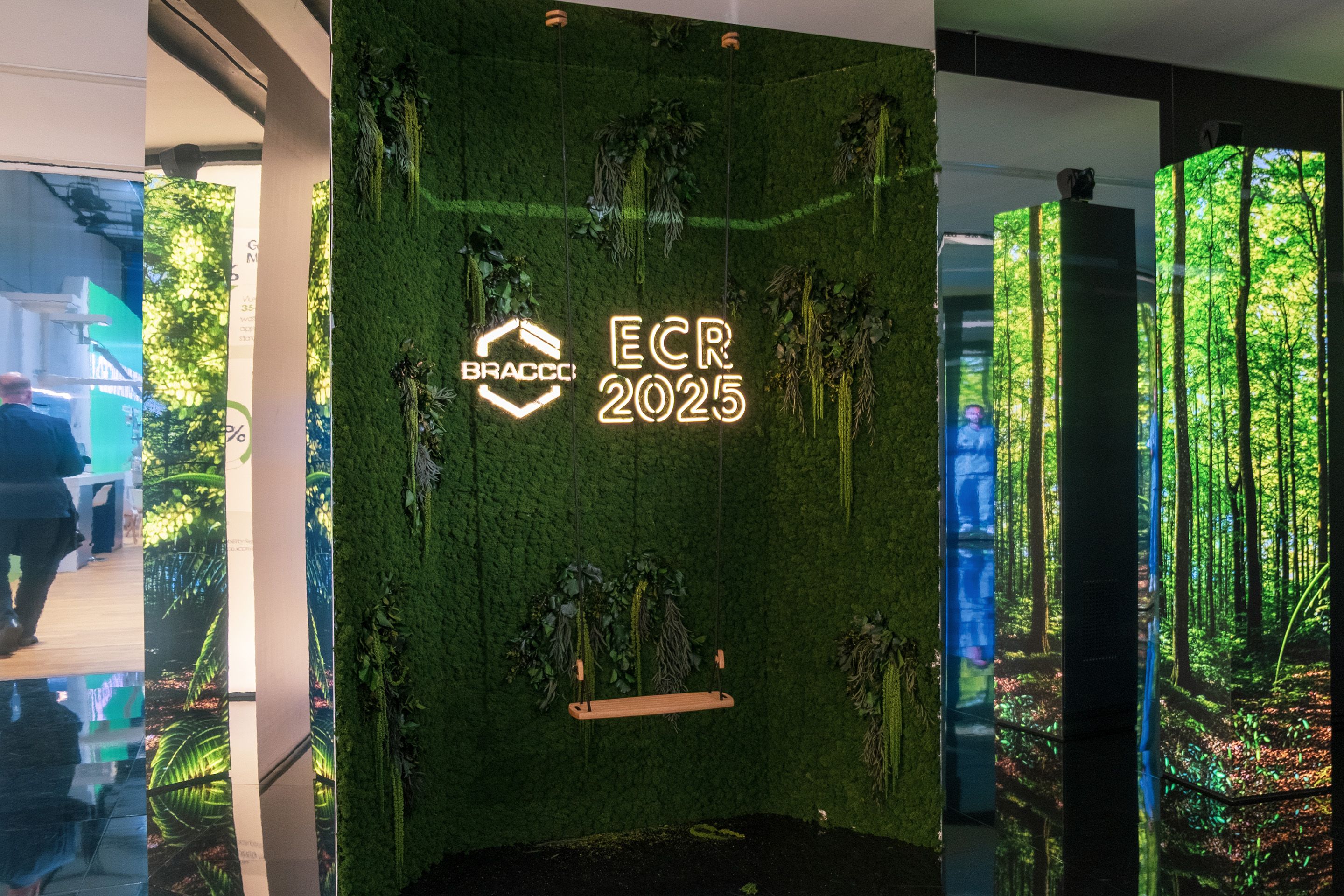 Dekoration und digitale Screens mit Wald-Optik Gang am ECR 2025 im Austria Center Vienna