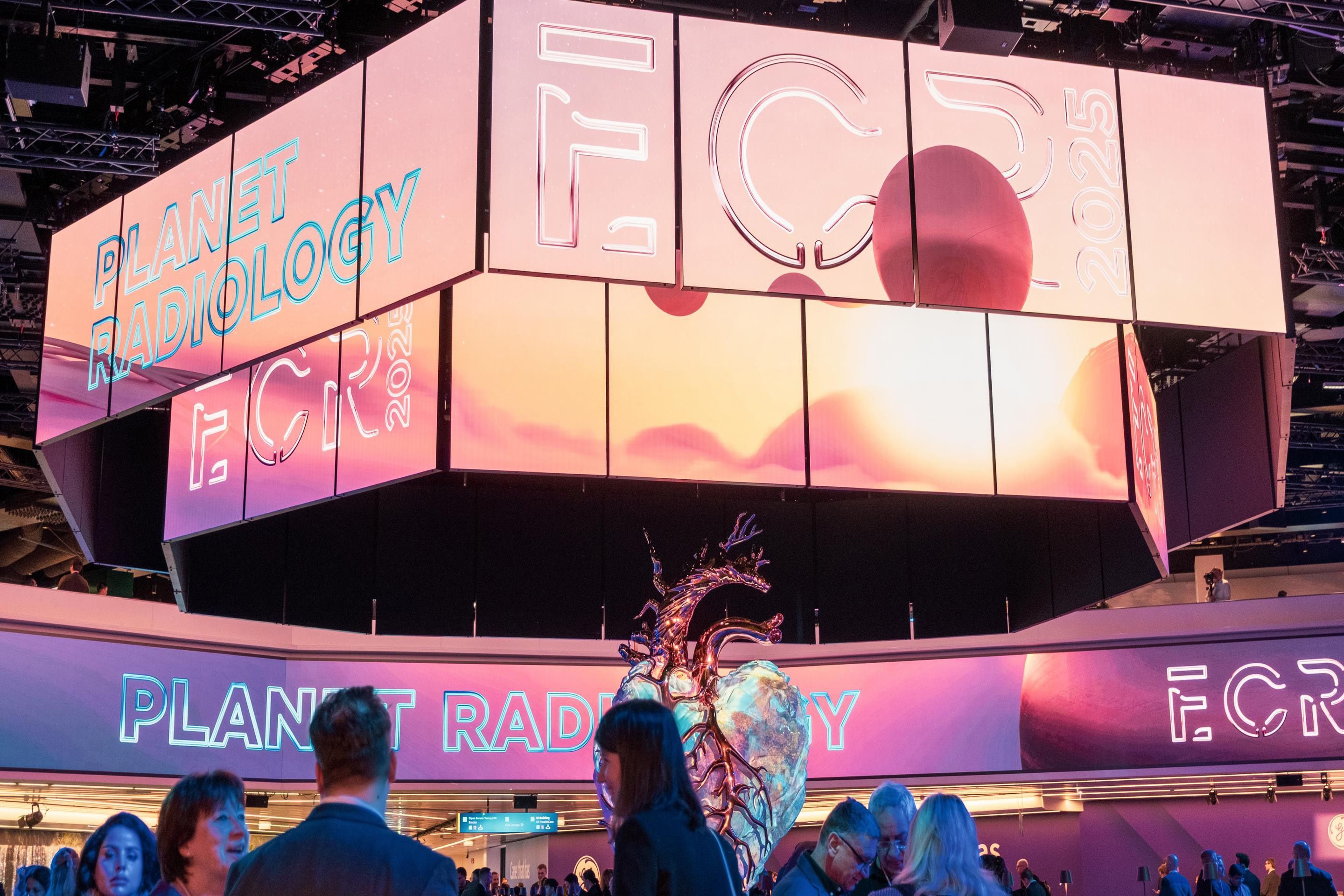 Large digital screens display "PLANET RADIOLOGY" and "ECR 2025" above a metallic anatomical heart sculpture.