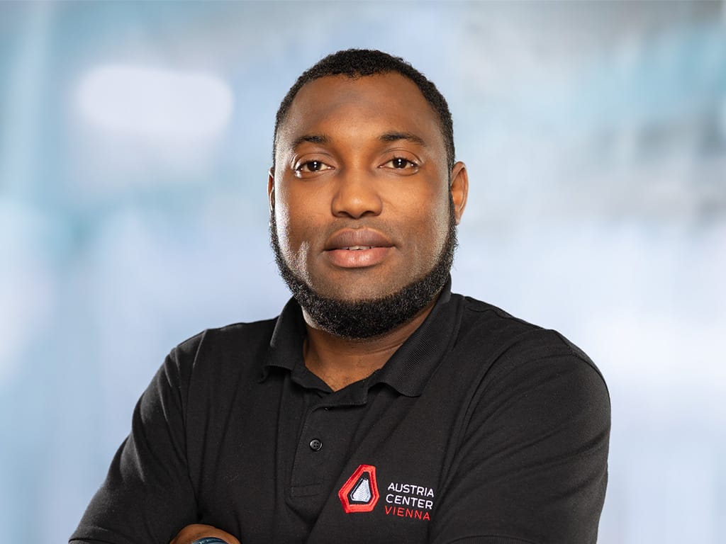 Person wearing a black polo shirt with Austria Center Vienna logo on the chest