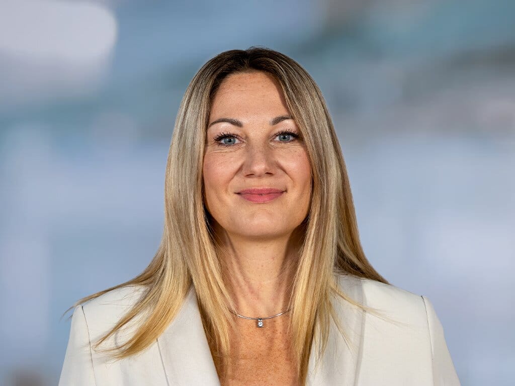Portrait of a woman with long hair in a light blazer, background