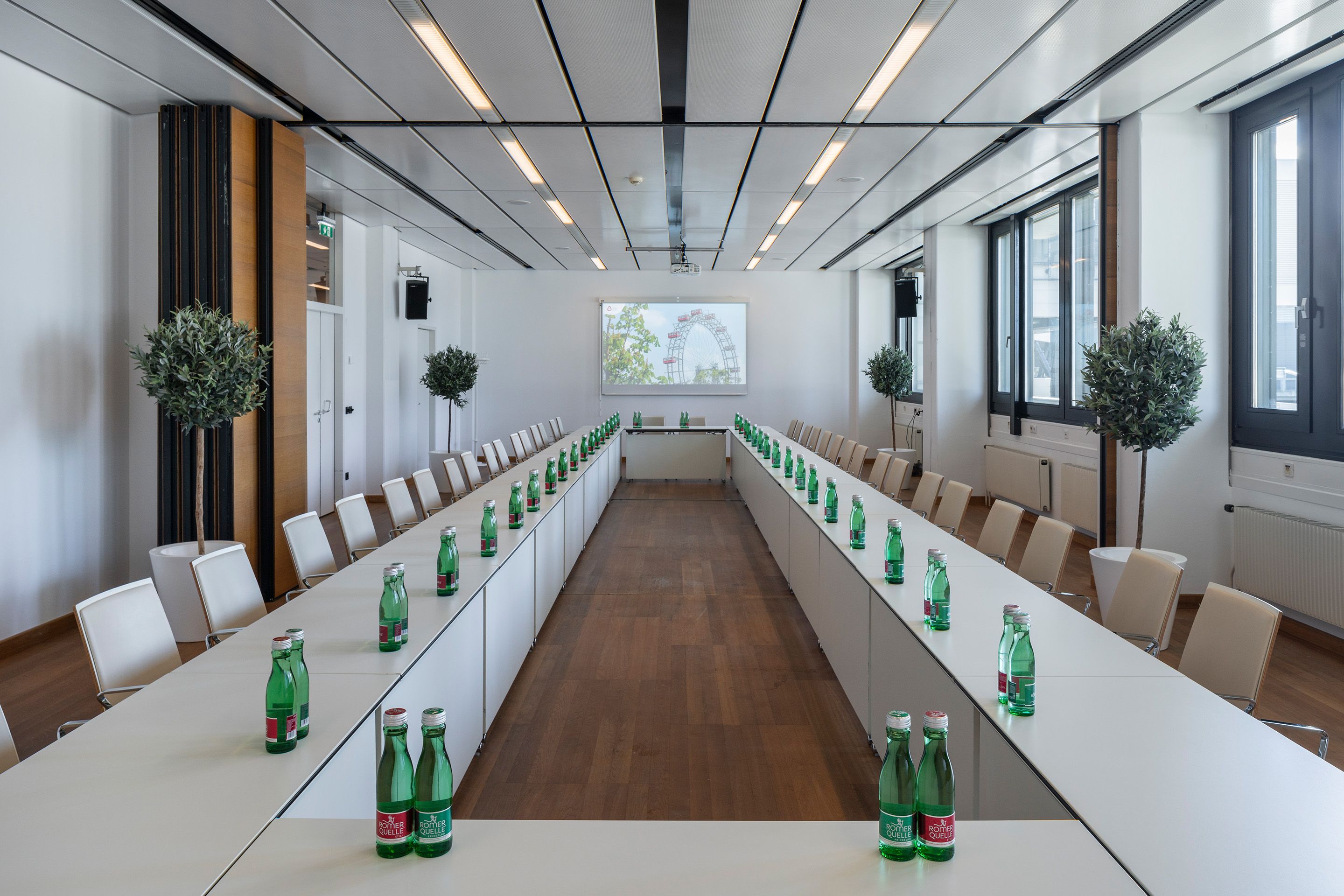 Foto: Raum 0.49-0.50 mit Leinwand, Tischen und Stühlen im Austria Center Vienna 