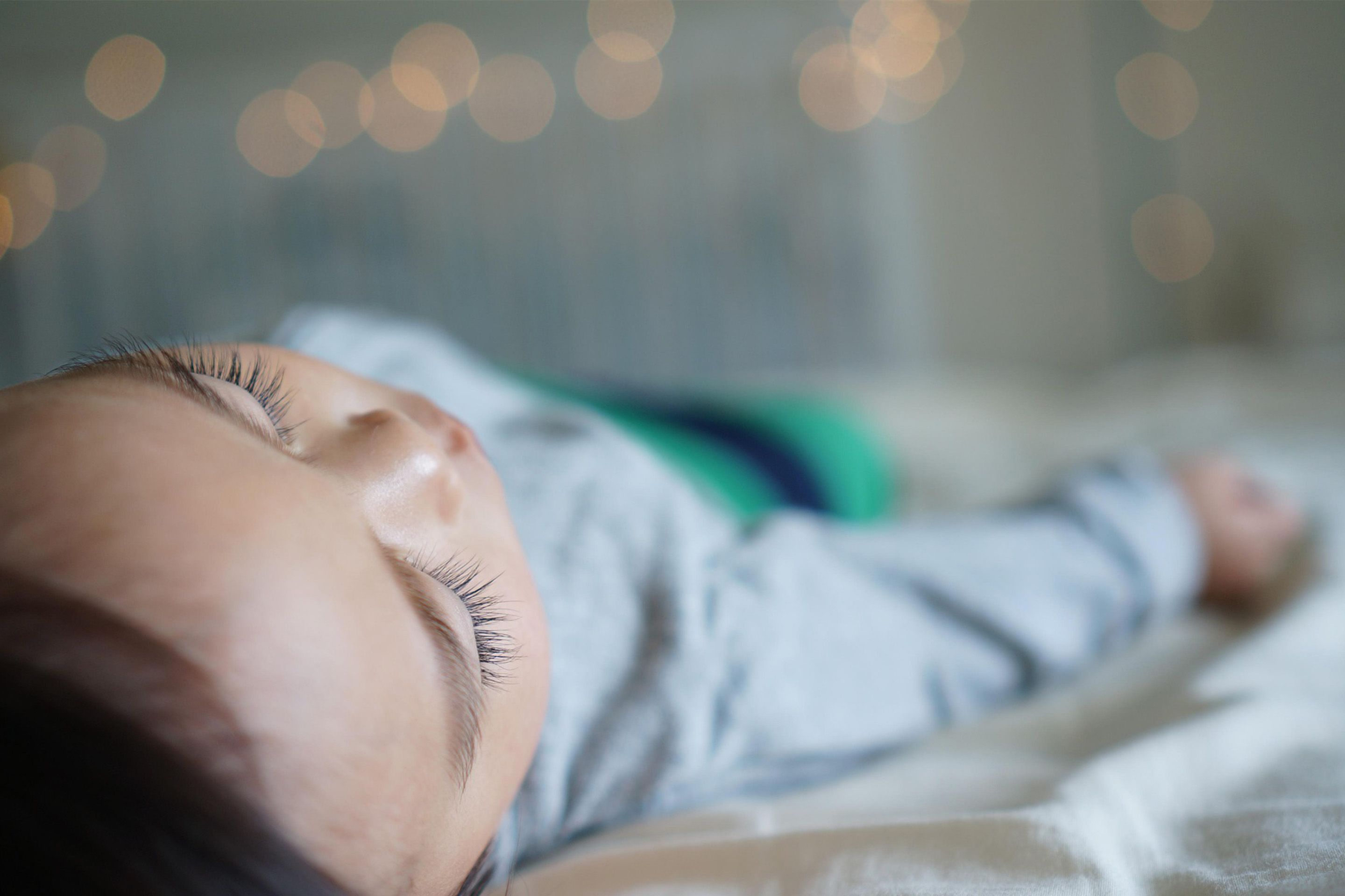 Foto: Kind liegt auf Bett