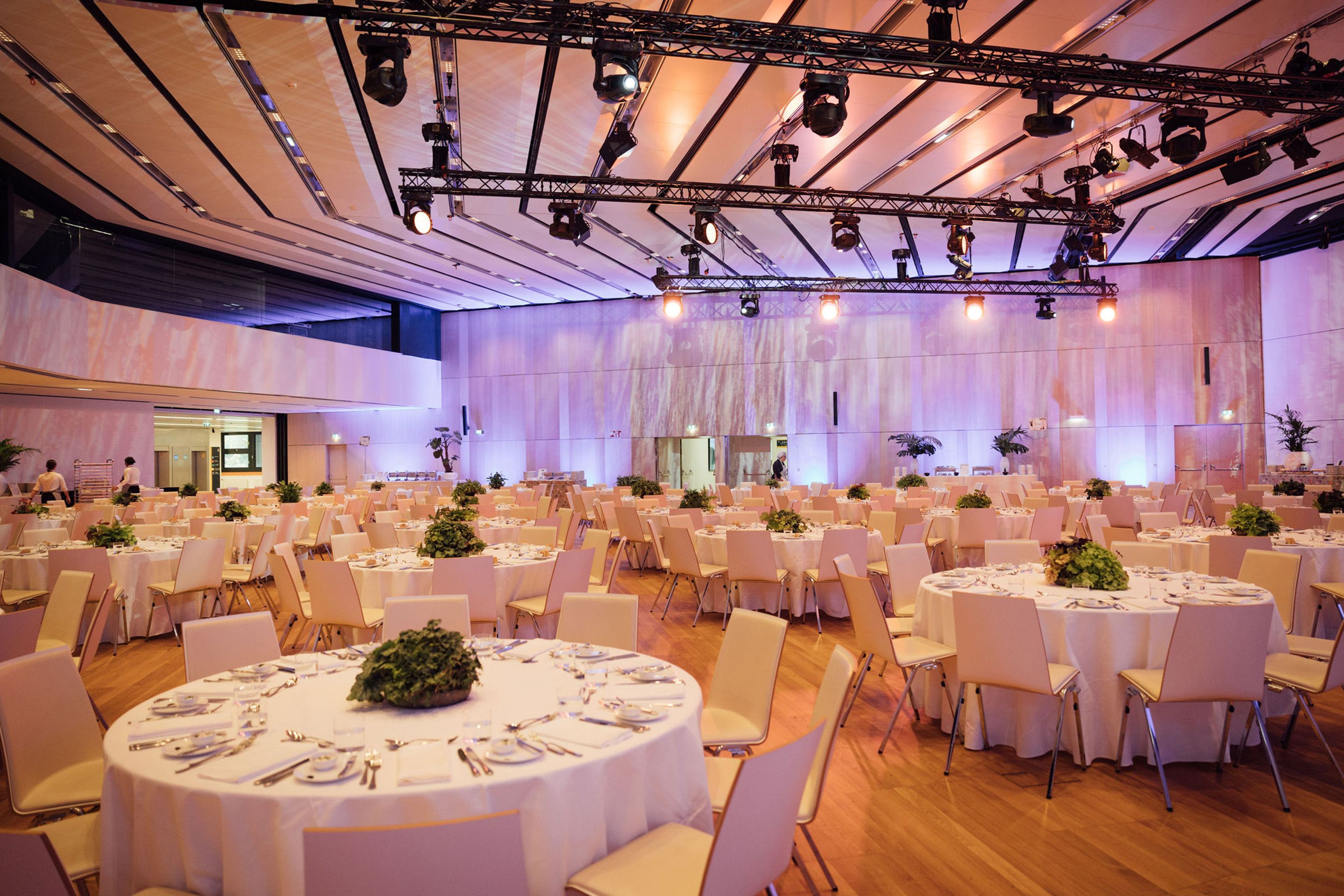 Foto: Runde Gala-Tische mit Stuehlen in einem Raum mit Holzboden