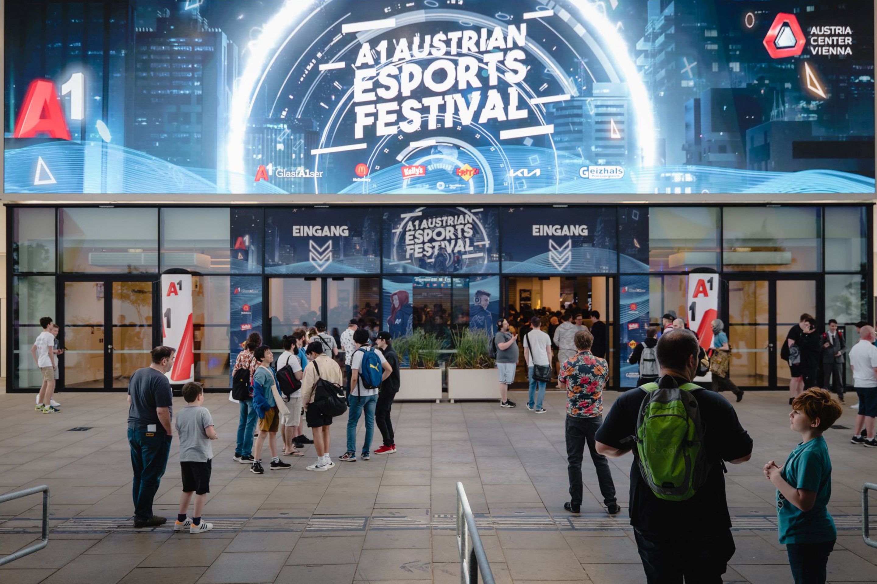 Foto: Menschen vor einem Eingang mit beleuchteter LED Wand