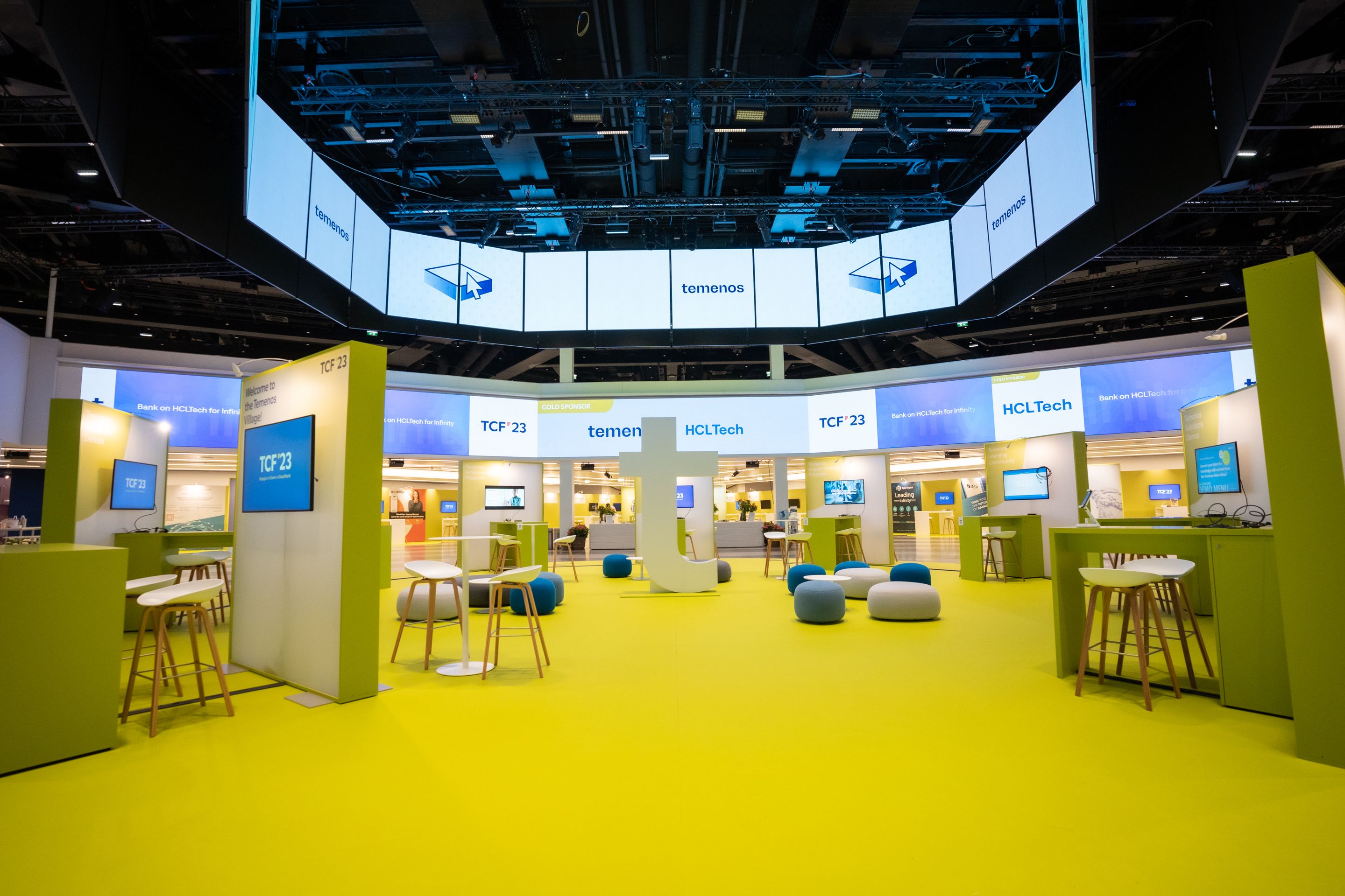 Foto: Raum mit gelben Teppich, Networking-Bereichen und beleuchteten LED-Flaechen an Decke und Waenden