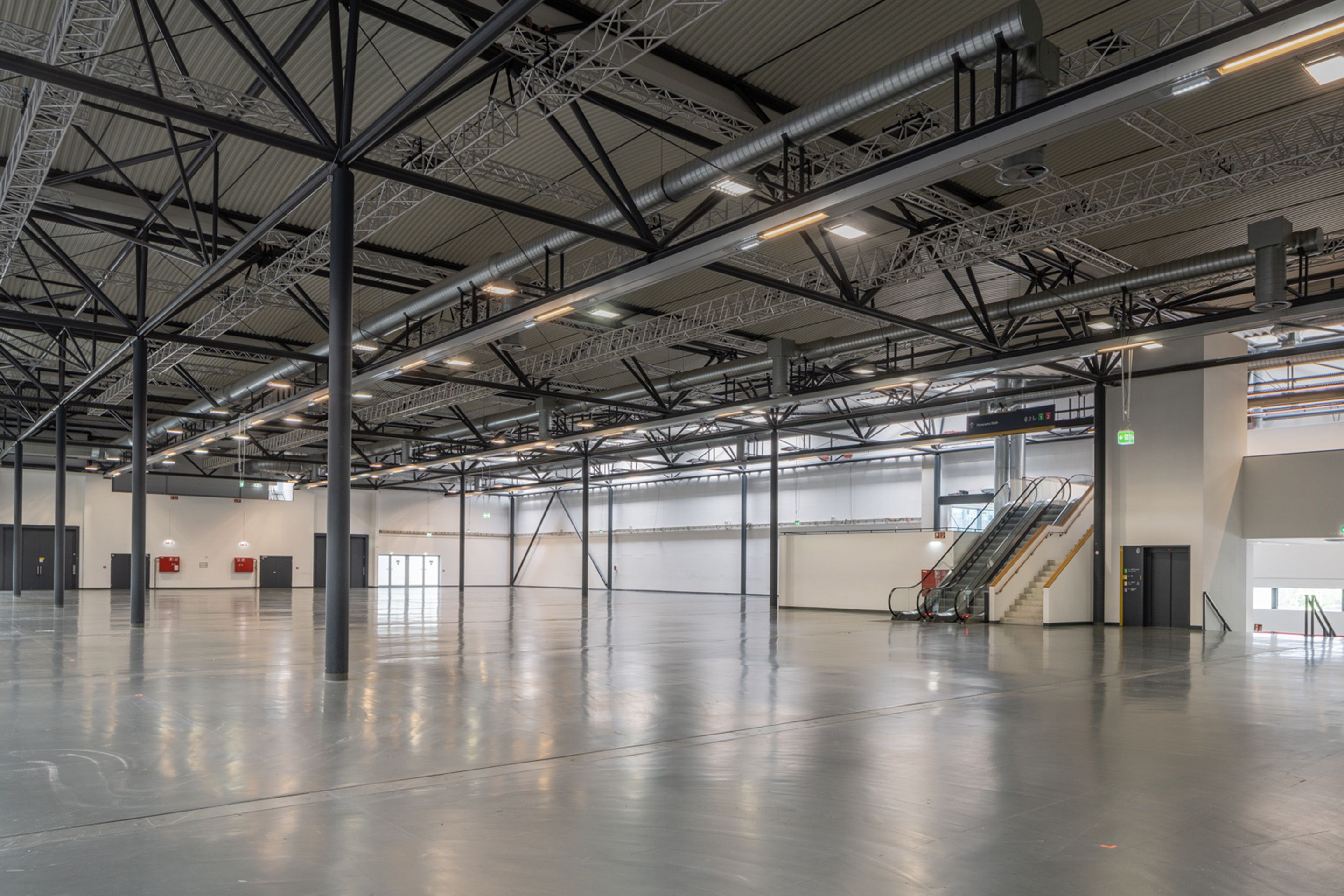 Foto: Halle mit hellem Boden und Saeulen und dunkler Decke