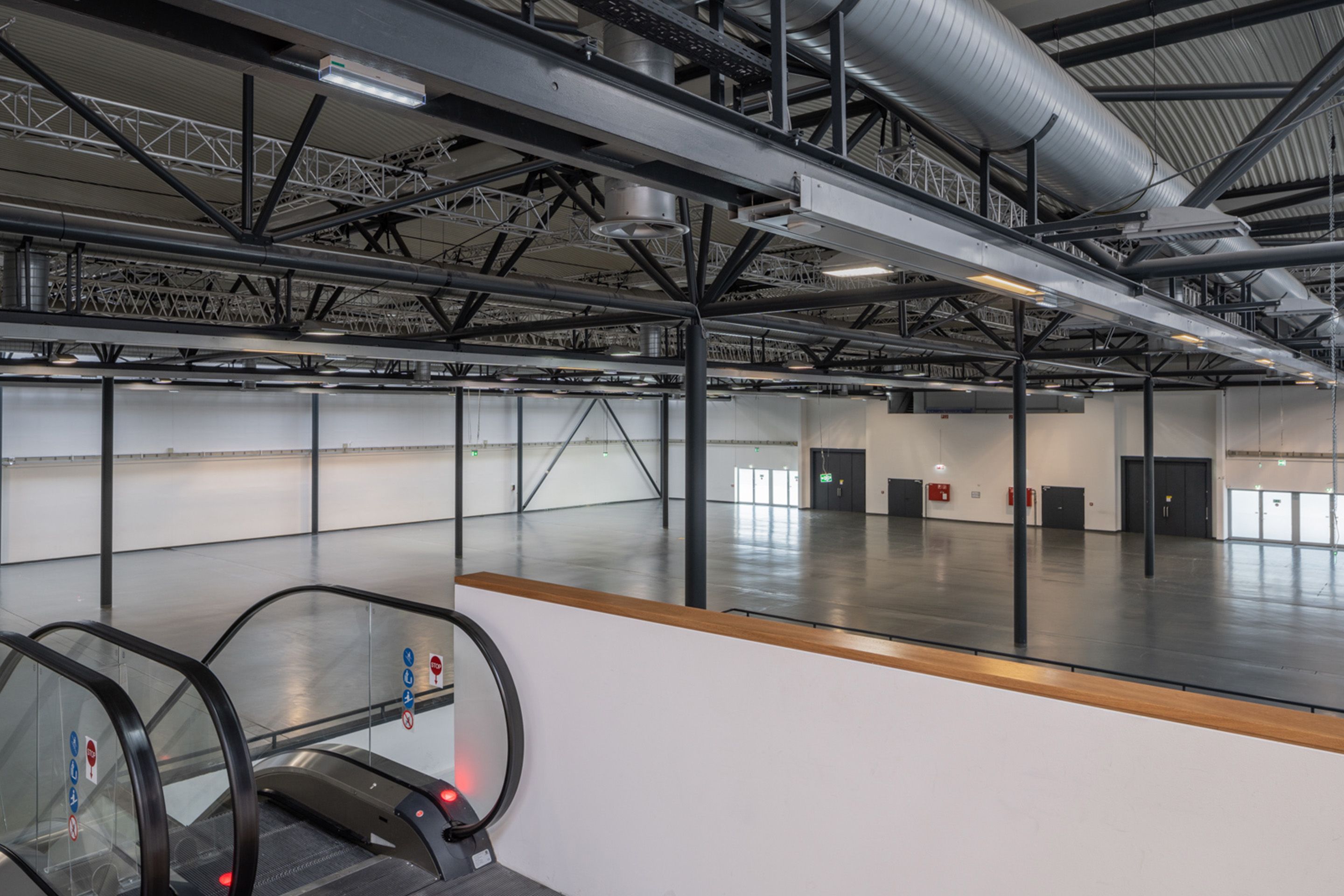 Foto: Rolltreppe von oben in eine Halle mit dunklen Saeulen