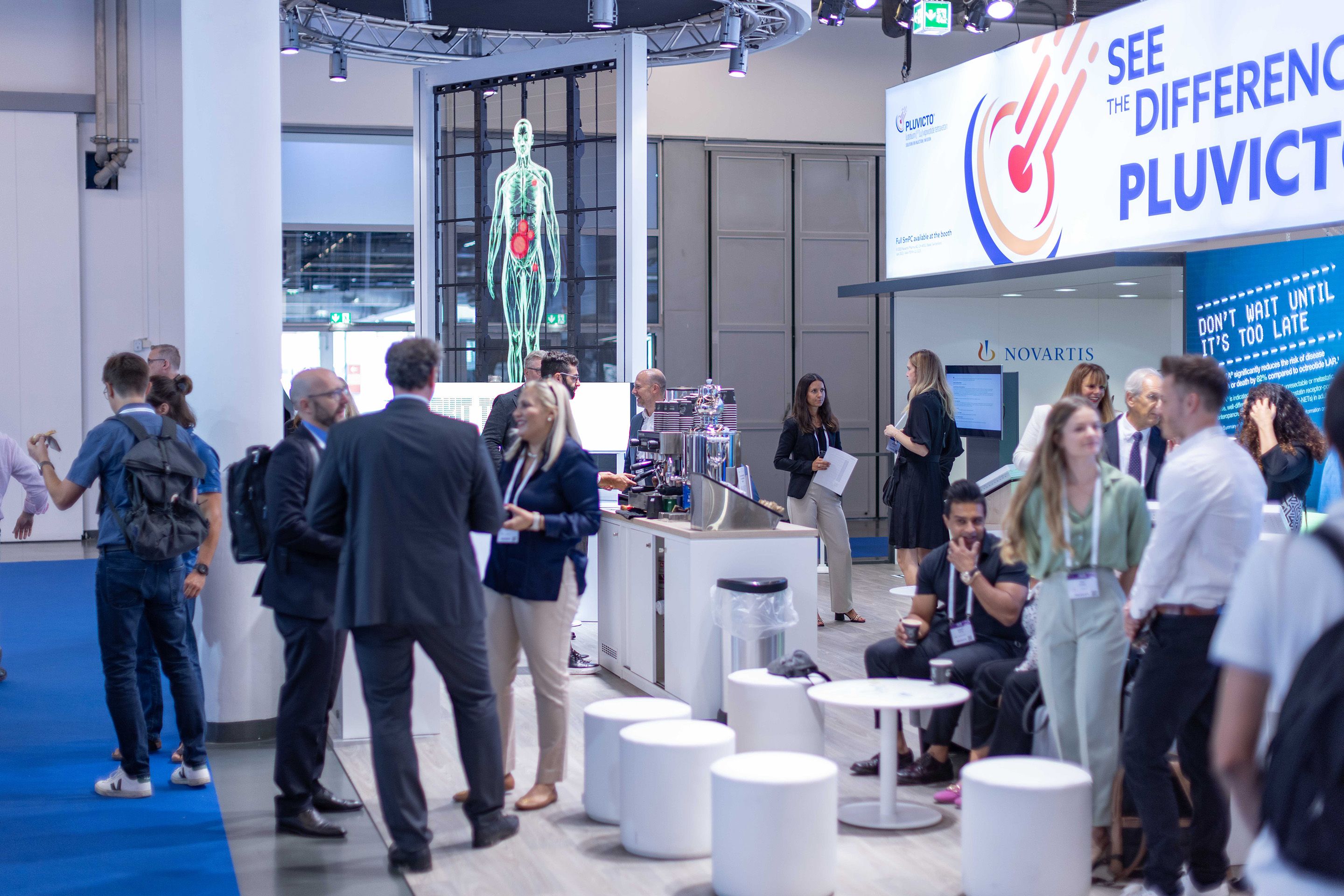 Foto: Messestand mit vielen Menschen in einer Halle