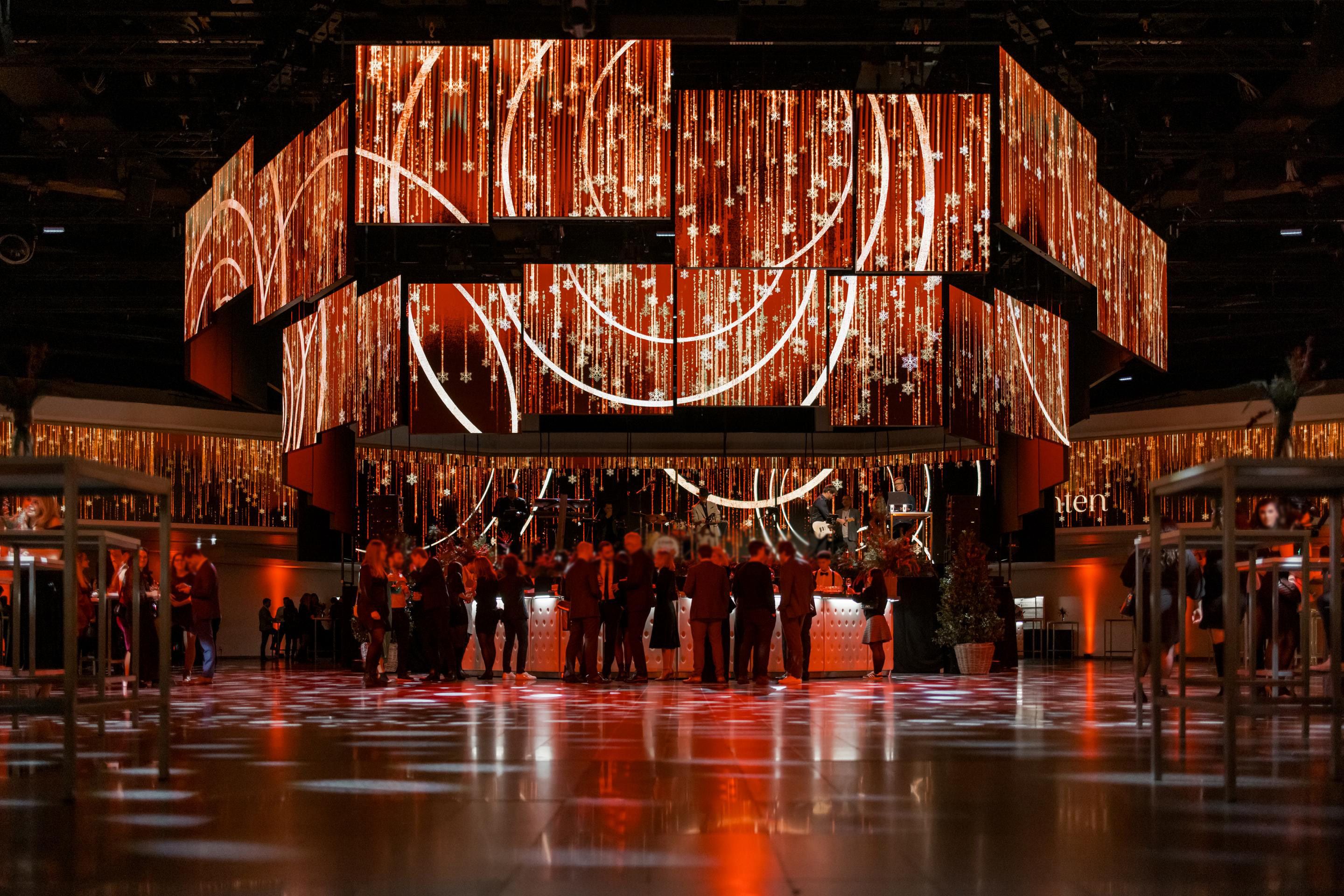 Foto: weihnachtlich beleuchtete LED- Paneele in einer Halle mit vielen Menschen