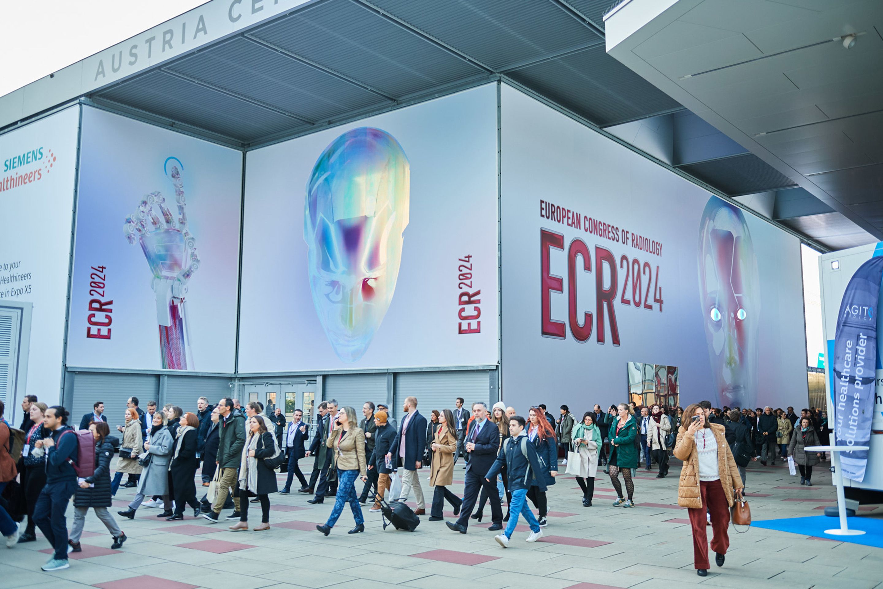 Foto: Halle mit einem Roboterkopf auf einem LED Screen und vielen Menschen