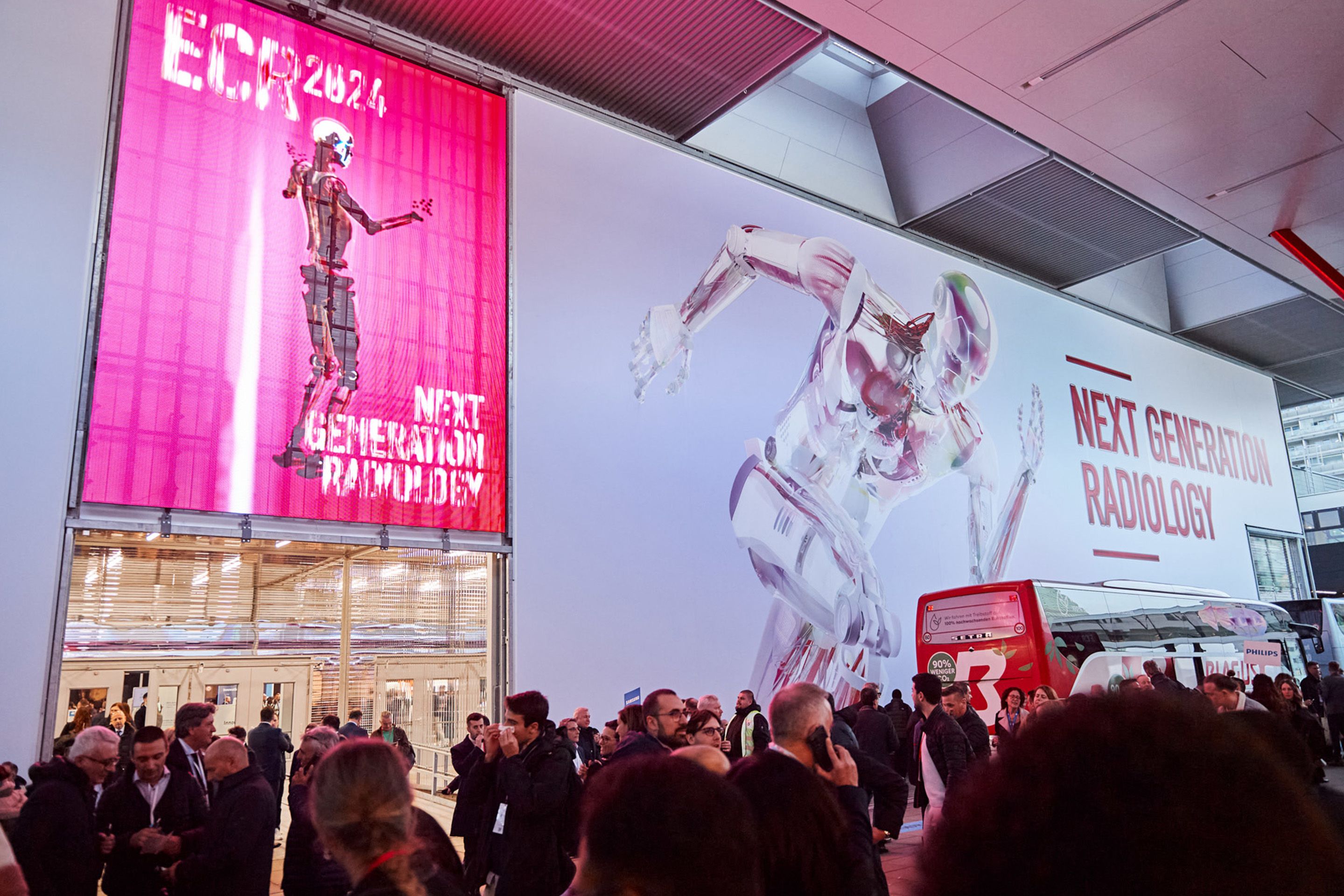 Foto: Eingang mit einem laufenden Roboter auf einem LED Screen und vielen Menschen