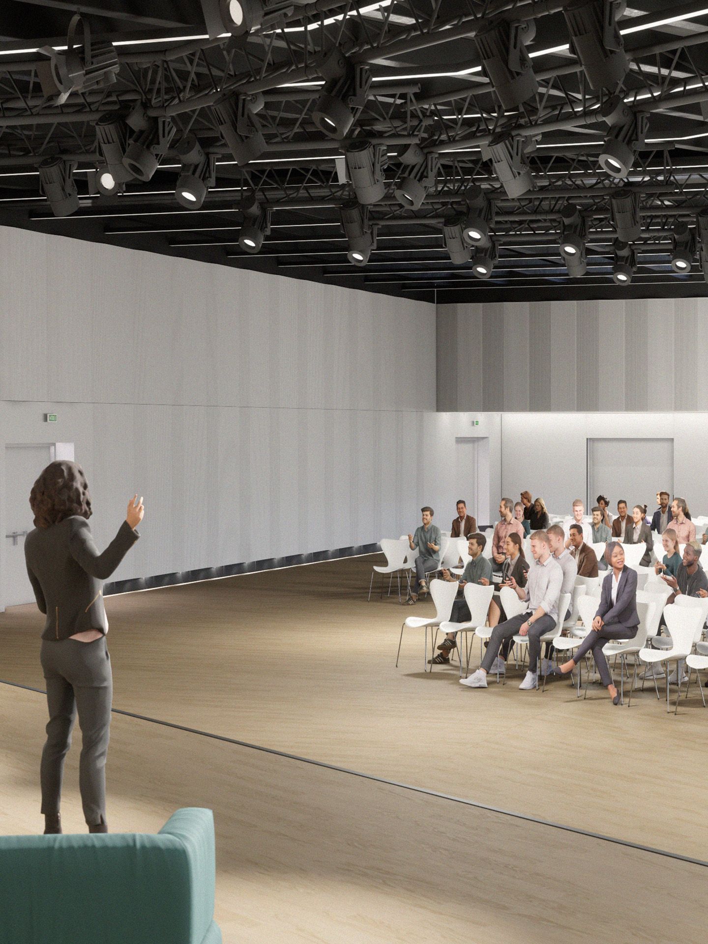 Mockup: einige Menschen sitzen auf weissen Stuehlen, vor ihnen eine Moderatorin auf deiner Buehne