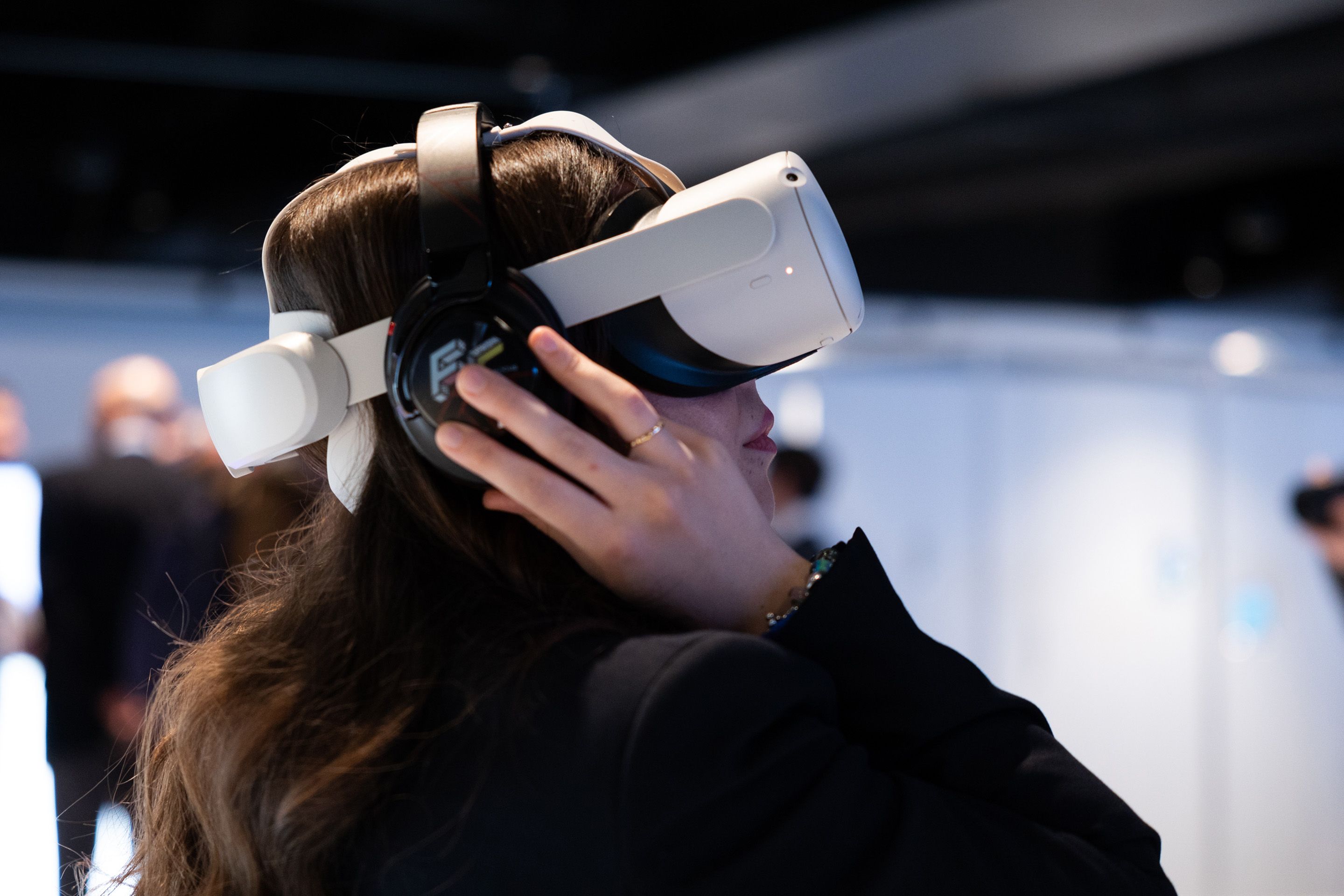 Eine Frau traegt eine VR-Brille und Kopfhoerer.
