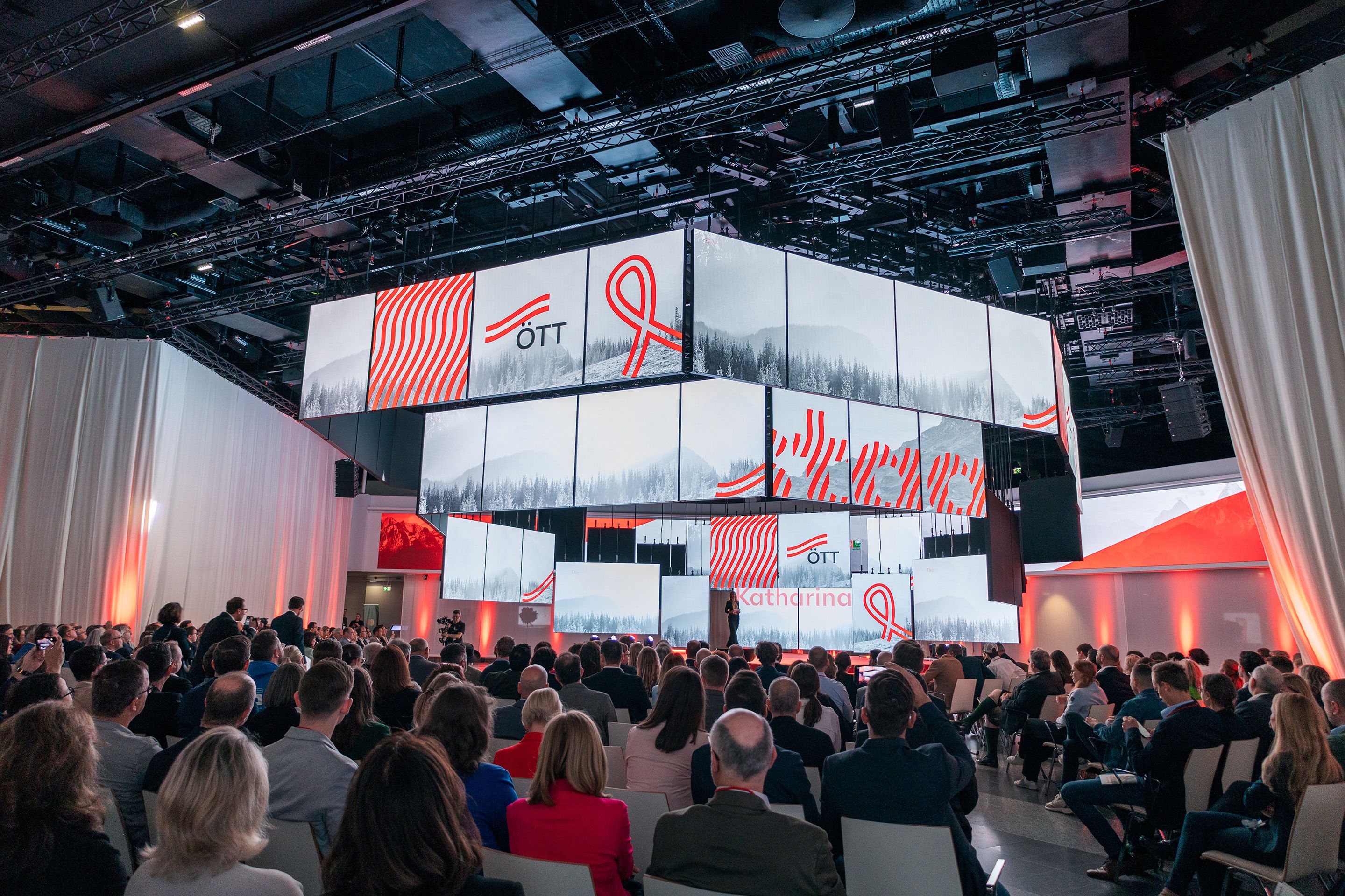 Eine Moderatorin steht auf der polySTAGE Buehne am Österreichischen Tourismustag 2024 vor Publikum im Austria Center Vienna.