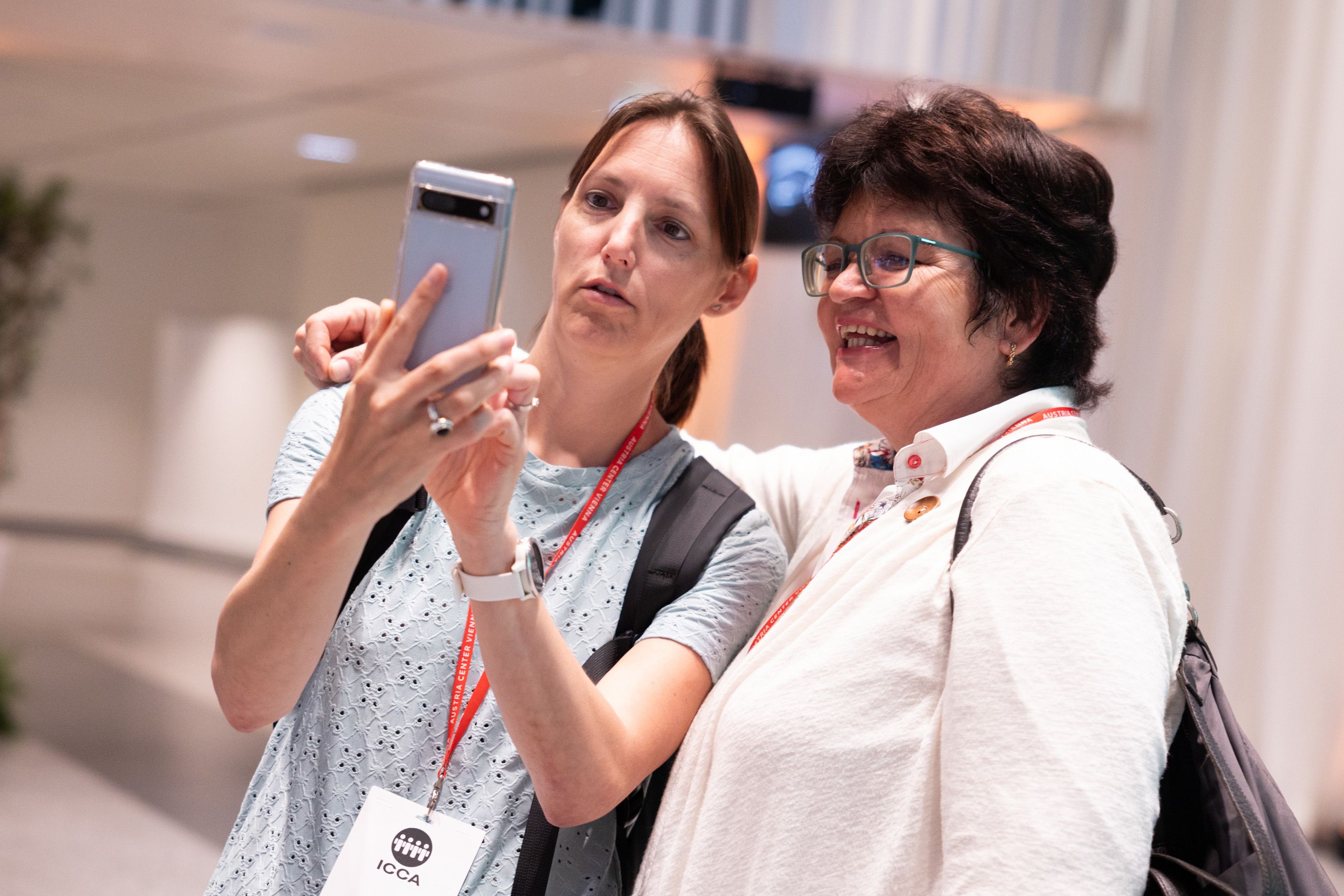 Zwei Frauen mit einem Smartphone am ICCA Client Supplier European Venue Workshop 2024 im Austria Center Vienna
