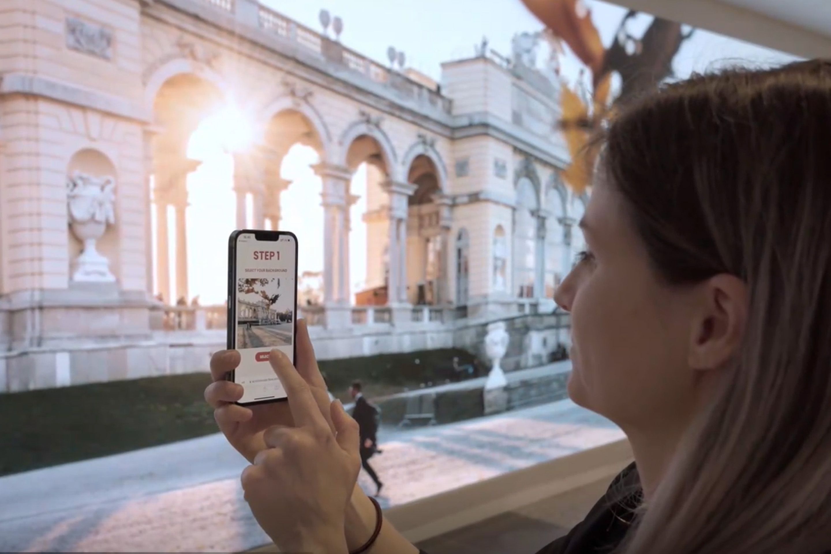 Frau interagiert mit Smartphone bei einer LED-Wand im Austria Center Vienna.
