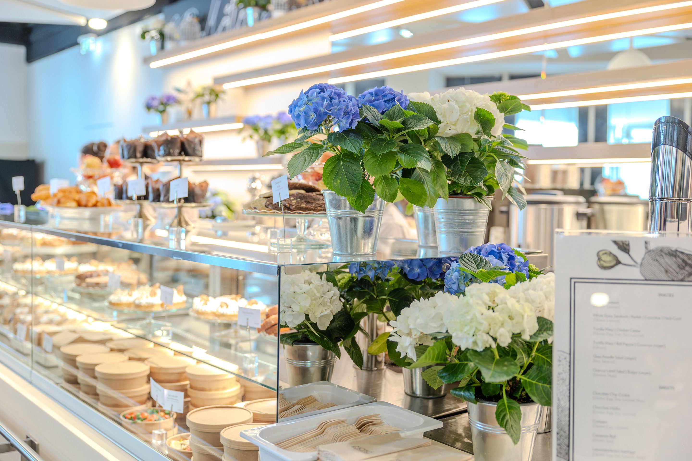 Buffet Vitrine mit Speisen und blauen und weissen Blumen in Toepfen