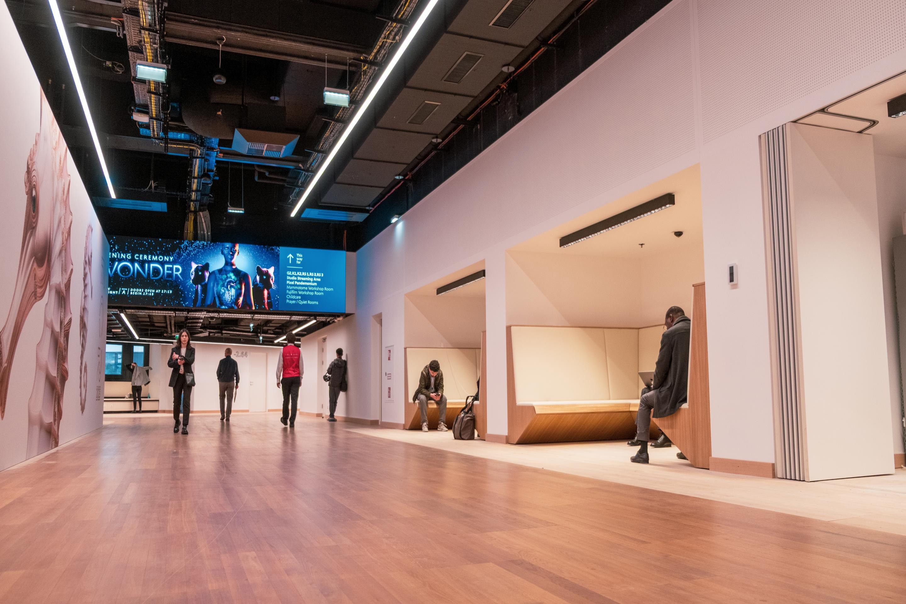 Foyer G Sitznischen mit Menschen und LED-Fläche am ECR 2025 im Austria Center Vienna
