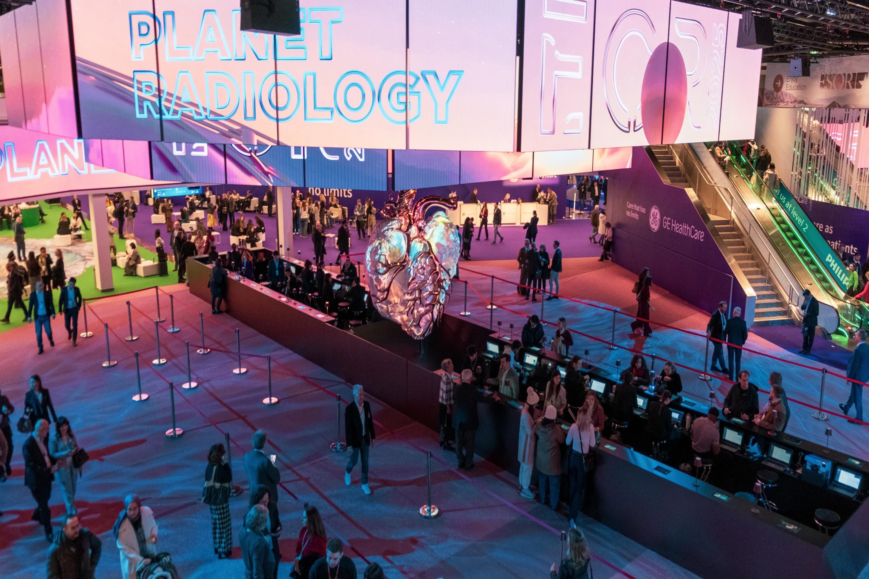 Eingangshalle mit polySTAGE und Herz-Skulptur mit vielen Menschen am ECR 2025 im Austria Center Vienna