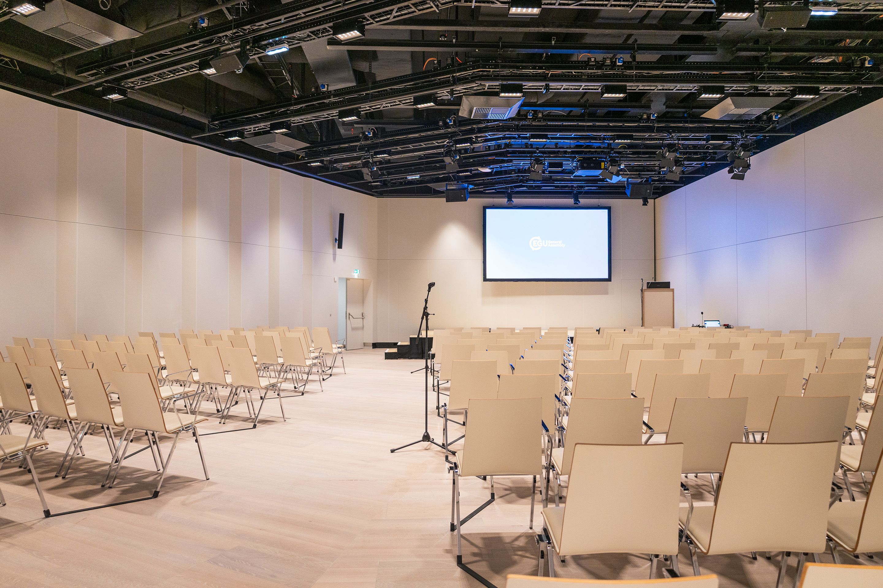 Saal K1 auf Level -2 im Austria Center Vienna mit Sitzreihen, Buehne und Leinwand