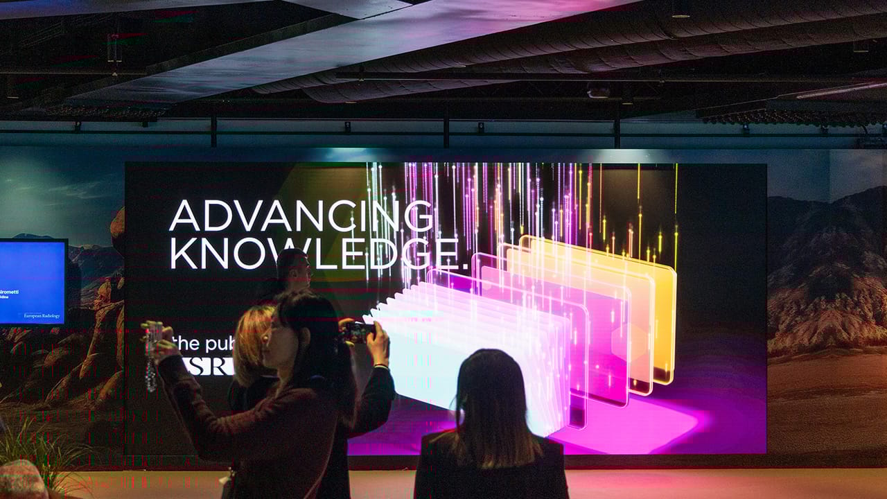 Zwei Teilnehmer fotografieren eine LED-Wall am ECR 2025 im Austria Center Vienna