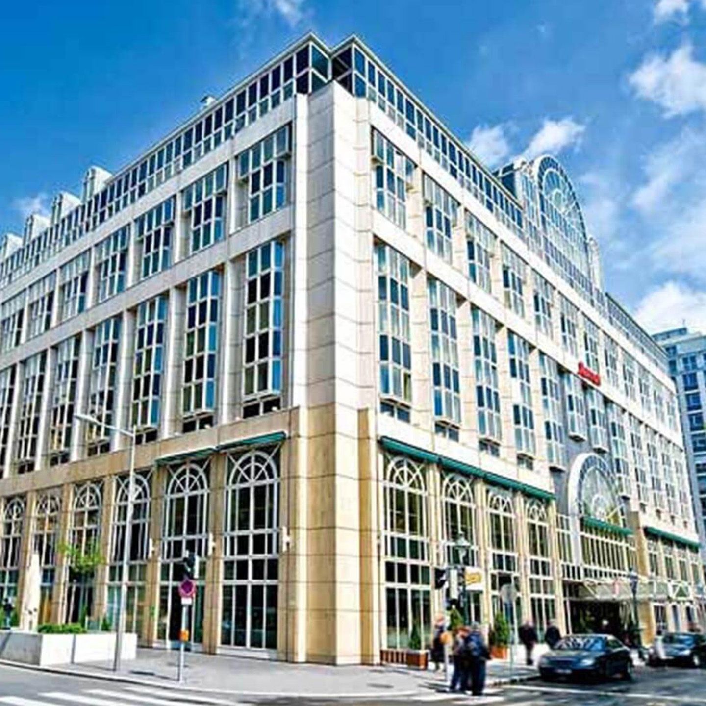 Das Mariott Hotel Vienna mit einigen Autos und Menschen vor dem Gebaeude