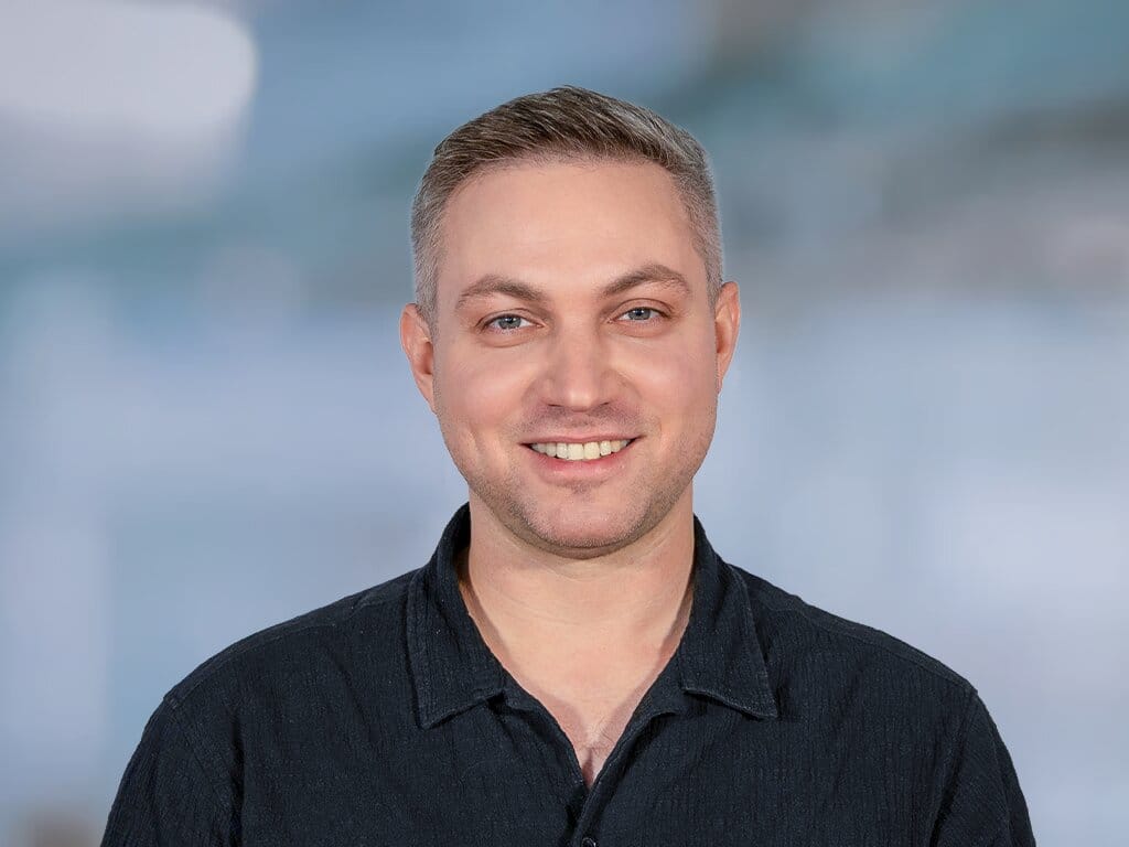 Porträt eines lächelnden Mannes vor hellem Hintergrund