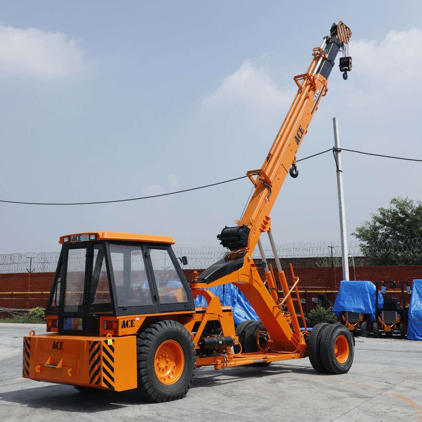 Gelber mobiler Kran steht auf grauer Betonfläche.